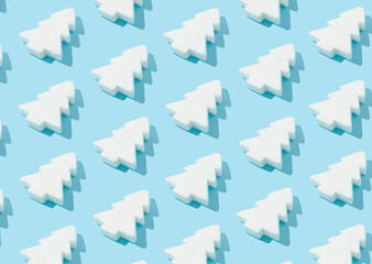 Pattern composition of white Christmas trees on pastel blue background. Minimalist isometric winter concept.