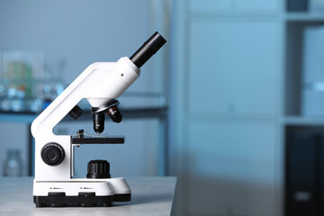 Modern medical microscope on gray table in laboratory, space for text - Powered by Adobe