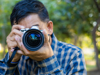 Senior photographer taking photos with a digital camera