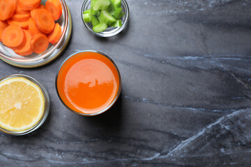Tasty carrot juice and ingredients on black marble table, flat lay. Space for text