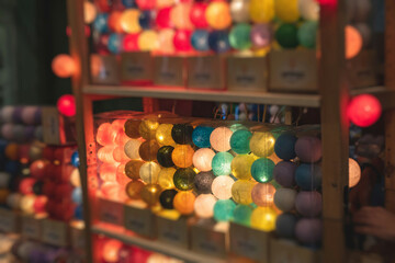 Crowded Christmas market with New Year decorations and multicolored flags, balloons, garlands and festoons, Xmas fair interior, retail sale kiosk and store with illumination