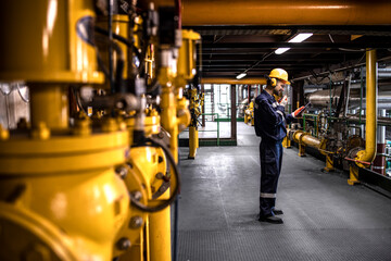 Petrochemical worker controlling process of crude oil production inside oil and gas refinery plant.