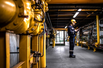 Petrochemical worker controlling process of crude oil production inside oil and gas refinery plant.