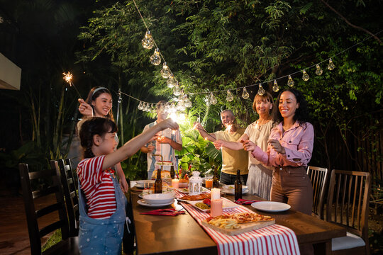 Multi-ethnic big family having fun, enjoy party outdoors in the garden.