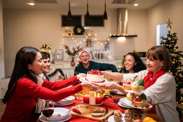 Multi-ethnic big family celebrating Christmas party together in house. 