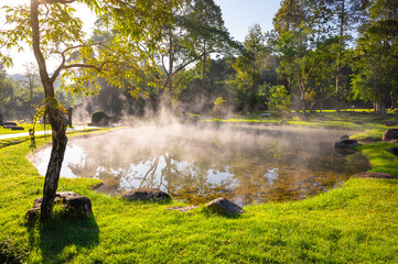 Natural hot spring with steam, rock and reflection in the morning at Chae Son National Park, Lampang, Thailand.