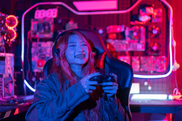 You win. Gamer using joystick controller plays online video game with computer neon lights backgrounds, woman use gaming headphones playing live stream esports games console at home.