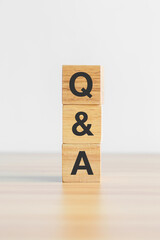 Questions and Ask word with wood block on table background. FAQ, frequency asked questions, Answer, Q and A, Information, Communication, questionnaire and Brainstorming Concepts