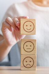 Hand choosing smile face from Emotion block for customer review, good experience, positive feedback, satisfaction, survey, evaluation, assessment, mood, world mental health day concept - obrazy, fototapety, plakaty