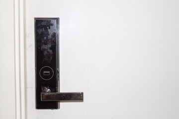 Entrance White
 door with electronic keycard lock system. Handle on door. The door locked by key-card.