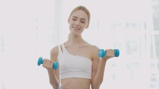 Beautiful young woman workout with lift up dumbbell for muscle while motivation and determined, one person, exercise and sport for muscular arm and hands, recreation and sport for health care concept.