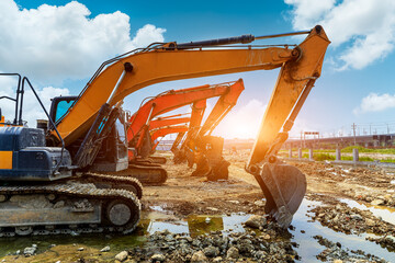 Construction site excavator equipment scene at sunset