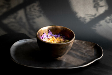 Herbal tea in rustic tea cup on Black background