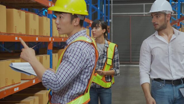 Young man applying shipping label to packaging and check document and manager talking in the warehouse at factory, worker writing and inspection manufacturing, logistic and shipping concept.