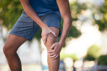 Knee pain, hands and man with injury during exercise, training and running in a park, pain and inflammation. Hand, fitness and arthritis in leg of runner during workout, sport and practice outdoors