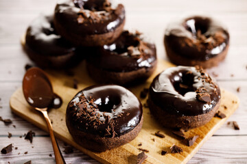 Chocolate donuts on wooden table background.