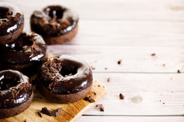 Chocolate donuts on wooden table background.