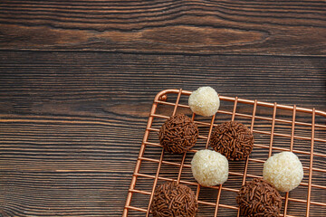 brazilian brigadeiro and beijinho traditional delicious chocolate dessert, party snacks, sweet sprinkle background top view over wooden table