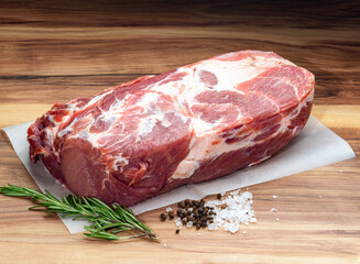 Pork shoulder with rosemary, rock salt, peppercorns on wax paper