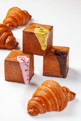 French crescent and cube shaped croissants with sweet sauces, chocolate flakes, pistachios and berry crumble