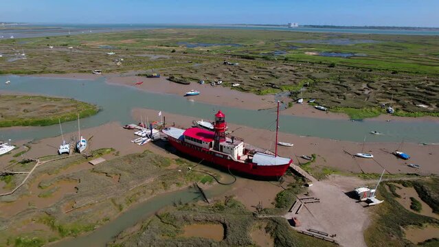 Converted Lightvessel Trinity (LV15) Of Fellowship Afloat Charitable Trust Surrounded By Mud Berths And Smaller Vessels In Tollesbury, Essex, England. - aerial