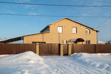 Two-storey cottage in the snow.