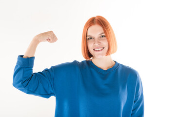 Fototapeta premium The girl shows biceps muscles on her arm on a white background.