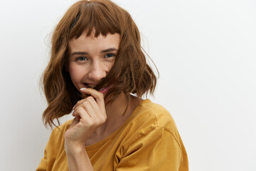 a close portrait of a happy, beautiful, attractive red-haired woman playfully hiding her face behind her hair