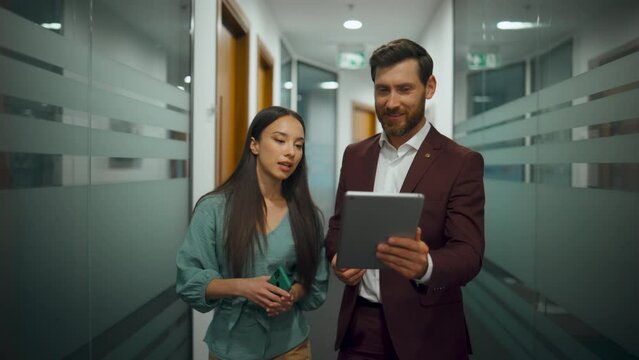 Smart people going through office closeup. Colleagues talking in modern corridor