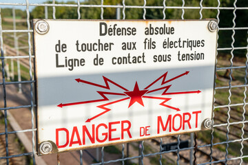 Panneau d'avertissement Sncf sur un grillage au dessus des voies ferrées : Défense de toucher aux fils, danger de mort - obrazy, fototapety, plakaty