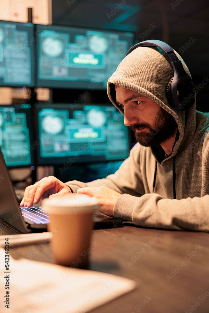 Poster thief developer breaking through security system and hacking computer server, working at night. dang