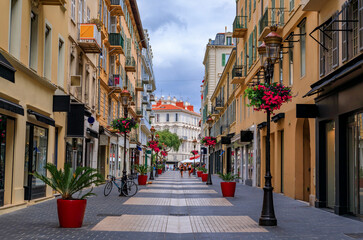 Ornate facades along a street decorated with flowers in Nice, South of France