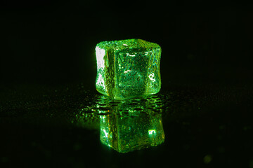 Green ice cubes on black background.