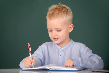 Kid writing in class. School boy studying math on lesson in classroom at elementary school.