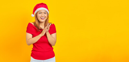 Smiling young woman wearing Christmas hat and applauding after presentation in a conference on...