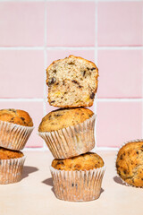 Close-up of chocolate and banana muffins in stack, colorful background, hard light