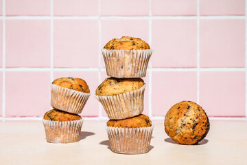 Chocolate and banana muffins in stack, colorful background, hard light
