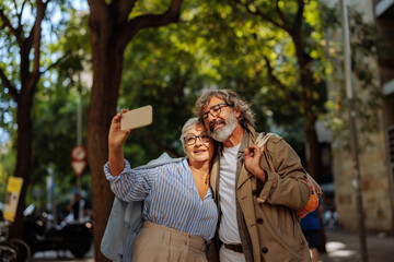 Senior couple taking selfie outside.