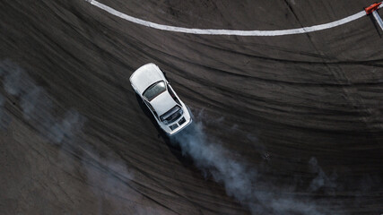 Aerial top view car drifting, Race drift car with lots of smoke from burning tires on speed track, Two car drifting battle on asphalt race track, Two drift cars battle with smoke from burned tire. - obrazy, fototapety, plakaty