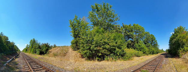 Panorama of straight railroad track under blue sky in Germany