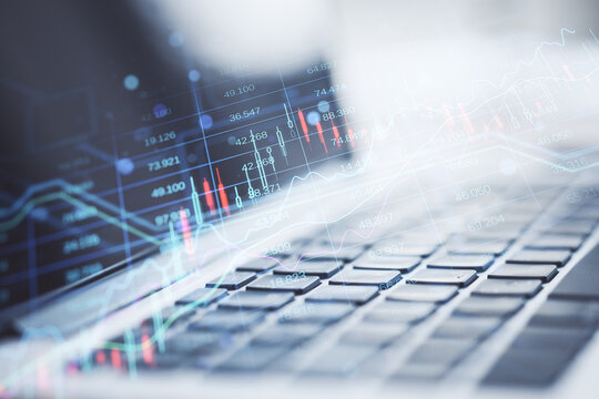 Close up of laptop computer keyboard with creative candlestick forex chart index hologram on blurry background. Trade, business market and finance analysis concept. Double exposure.