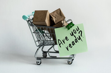 A sticker attached to a decorative grocery cart along with small packaged mailboxes. The content of the inscriptions matters for stores, sales and marketing. 
