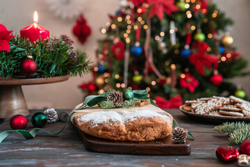 Fototapeta na wymiar Homemade Christmas stollen on wooden table with winter holidays decoration. Traditional Christmas pastry dessert – Stollen. Xmas greeting card. 