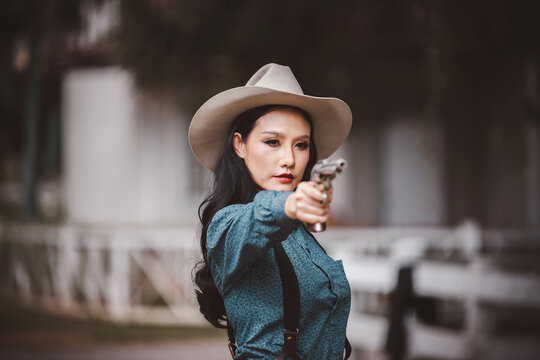 Portrait cowboy wearing in western style suite with hat posing show gun or  retro cowboy weapon is vintage lifestyle concept. 