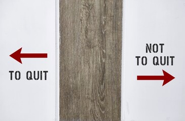 Wall with text written TO QUIT and  NOT TO QUIT and direction sign, concept of decision making to...
