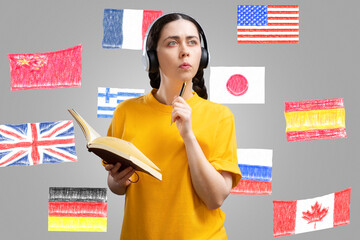 Learning of foreign language.Thoughtful caucasian young woman wearing headphones holding book and...