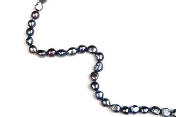 Baroque pearls strand. Natural freshwater black pearl beads on white background. Side view