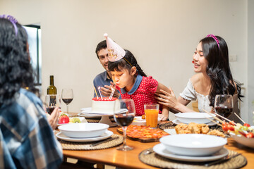 Multi-ethnic big family having a birthday party for young kid daughter. 