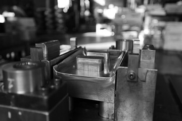 Sheet Metal Stamping Tool Die for Automotive Precision Parts on The Numerical Control Milling Machine Table. Tandem Stamping System. At a High Quality Technology Factory. Black and White Photography.