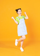 Full length image of young Asian woman standing on background